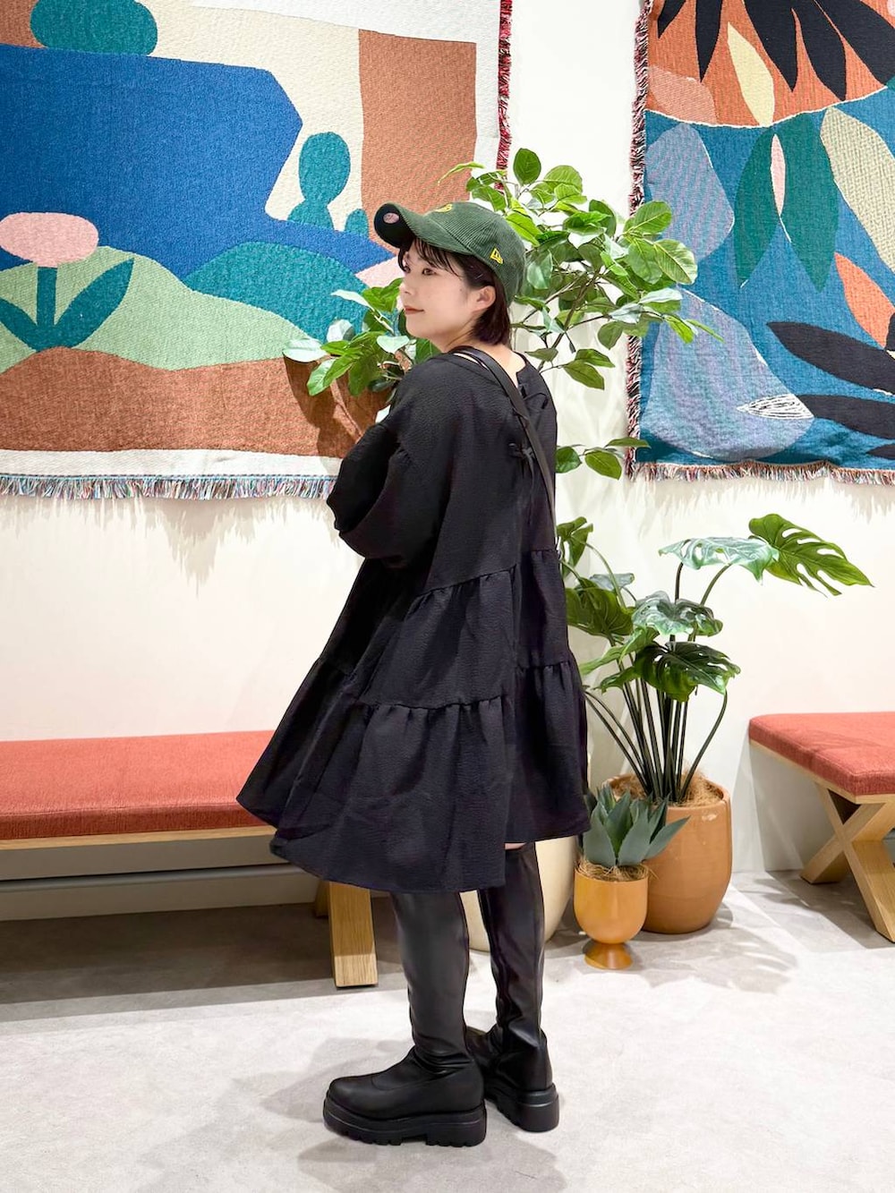 ブラック系のショルダーバッグ、ブラック系のブーツ、ブラック系のワンピースを着用したレディースの秋コーディネートの3枚目の写真