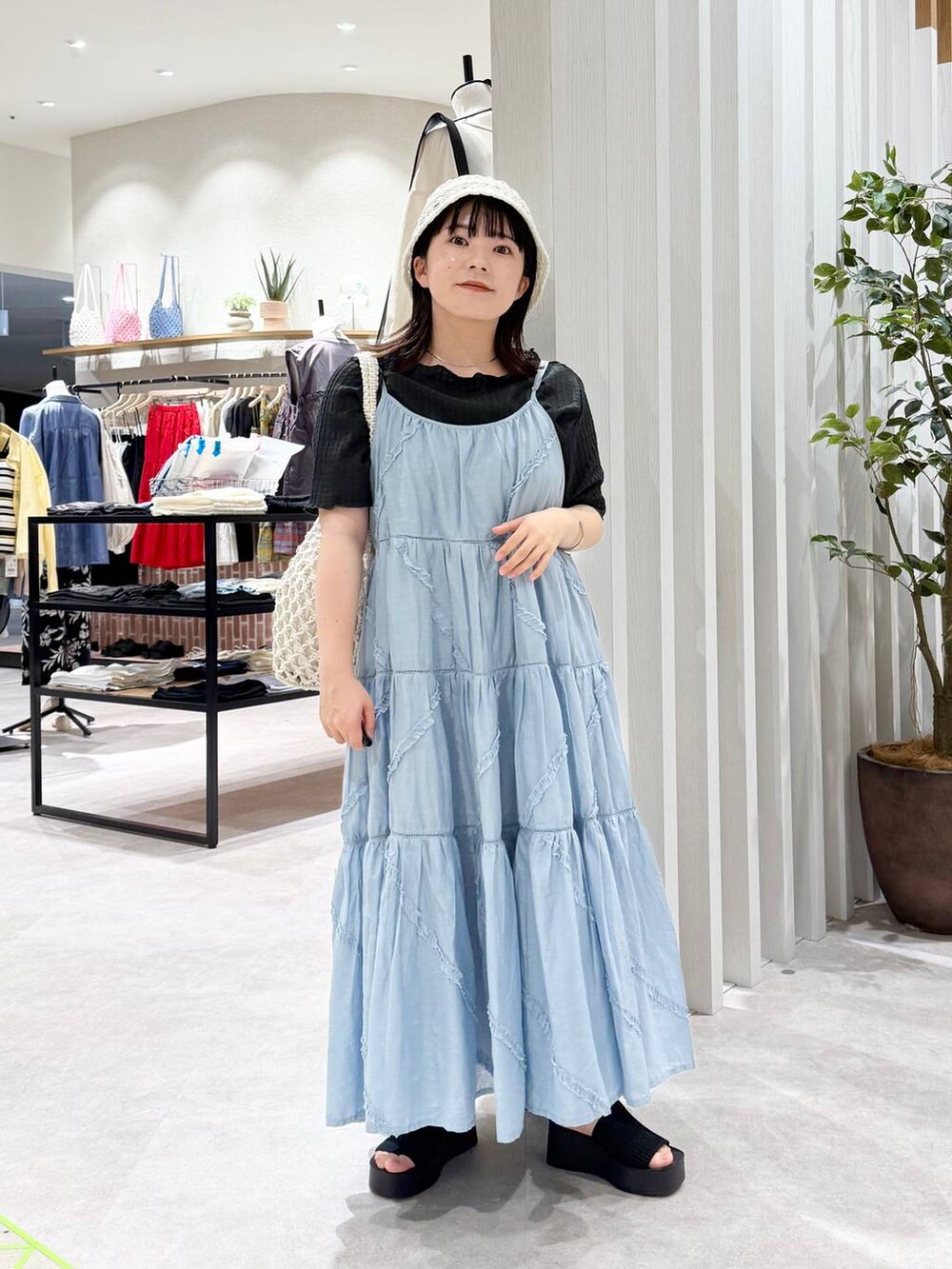 ブラック系のサンダル、ホワイト系のトートバッグ、ブルー系のワンピースを着用したレディースの春コーディネートの5枚目の写真