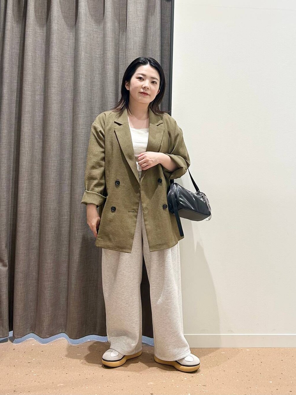 ブラウン系のテーラードジャケット、ホワイト系のTシャツ/カットソー、ブラック系のトートバッグを着用したレディースの春コーディネートの3枚目の写真