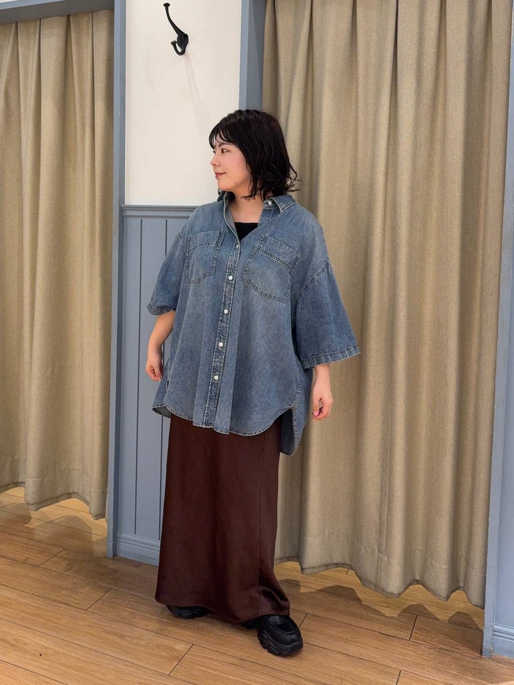 ブラウン系のスカート、ブラック系のローファー、ブルー系のシャツ/ブラウスを着用したレディースの春コーディネートの3枚目の写真