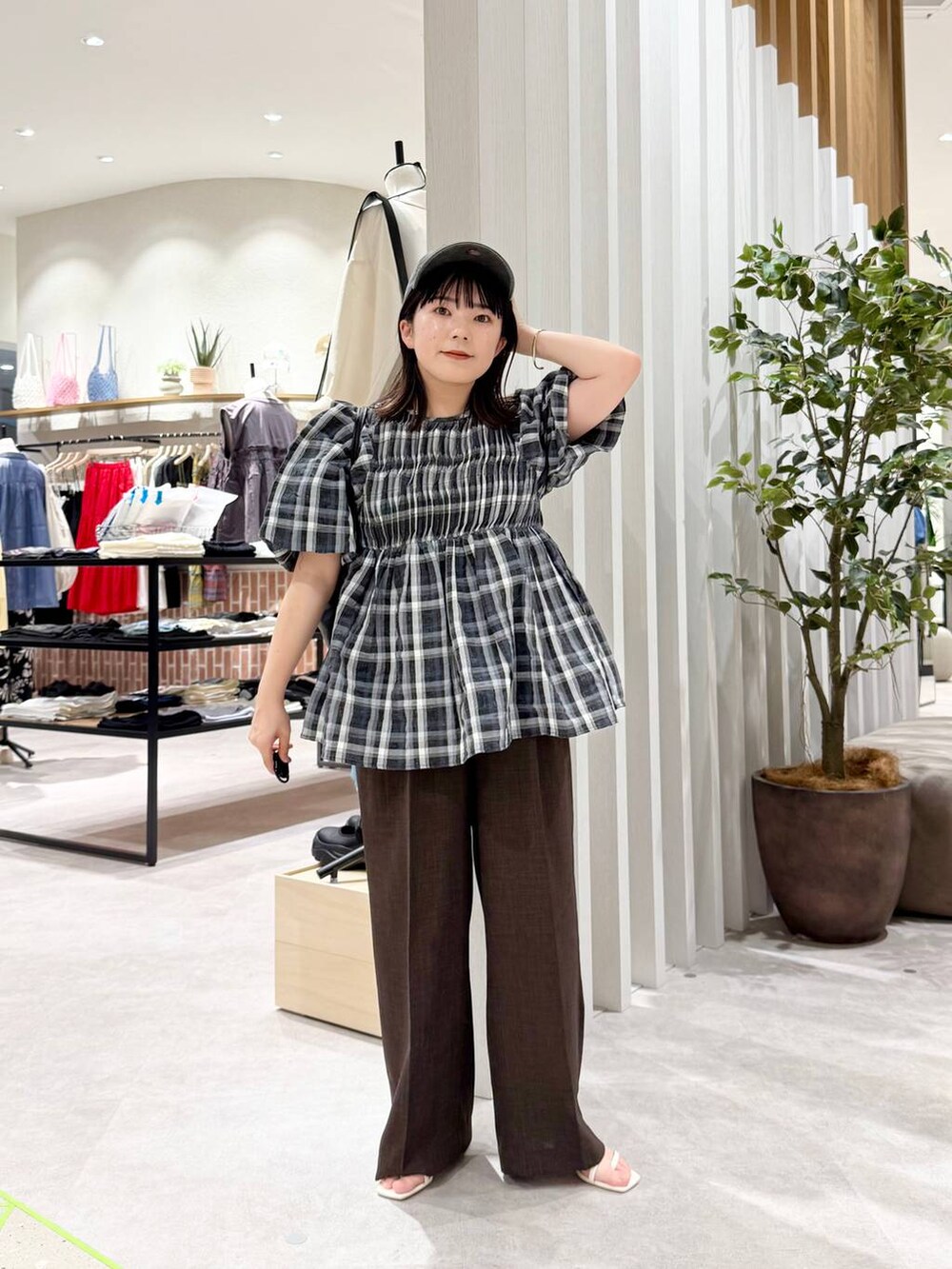 ブラック系のシャツ/ブラウス、ホワイト系のサンダル、ブラック系のショルダーバッグを着用したレディースの春コーディネートの2枚目の写真