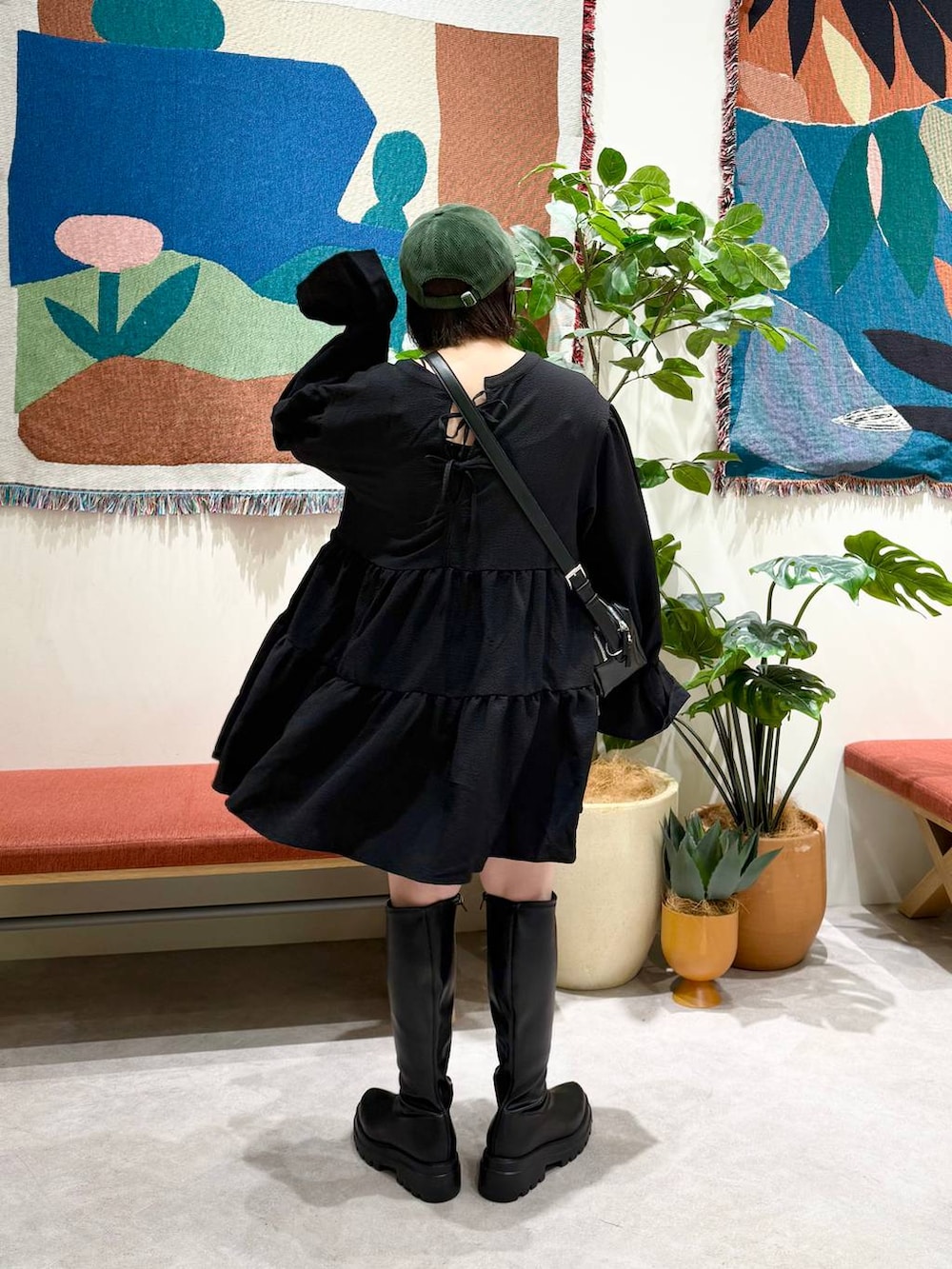 ブラック系のショルダーバッグ、ブラック系のブーツ、ブラック系のワンピースを着用したレディースの秋コーディネートの4枚目の写真