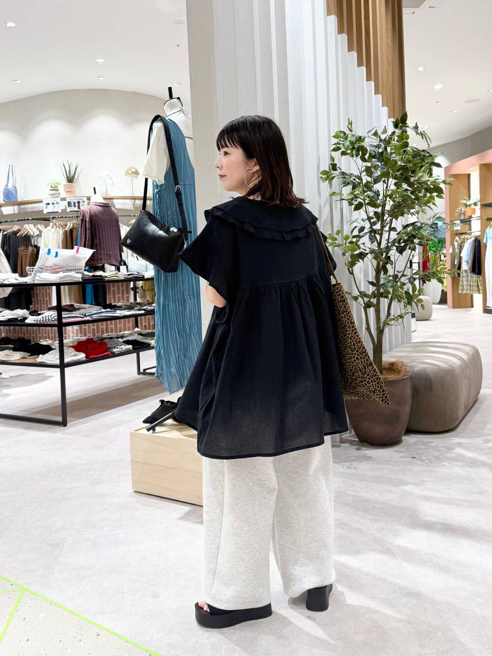 ブラック系のサンダル、その他のトートバッグ、グレー系のデニムパンツを着用したレディースの春コーディネートの3枚目の写真