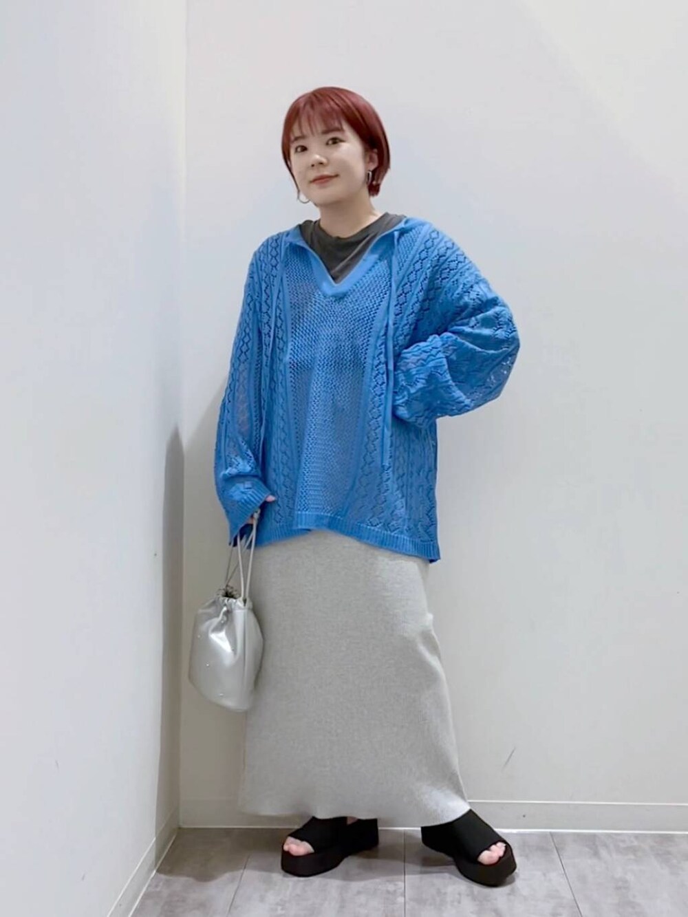 グレー系のスカート、ブルー系のニット/セーター、シルバー系のショルダーバッグを着用したレディースの春コーディネートの5枚目の写真