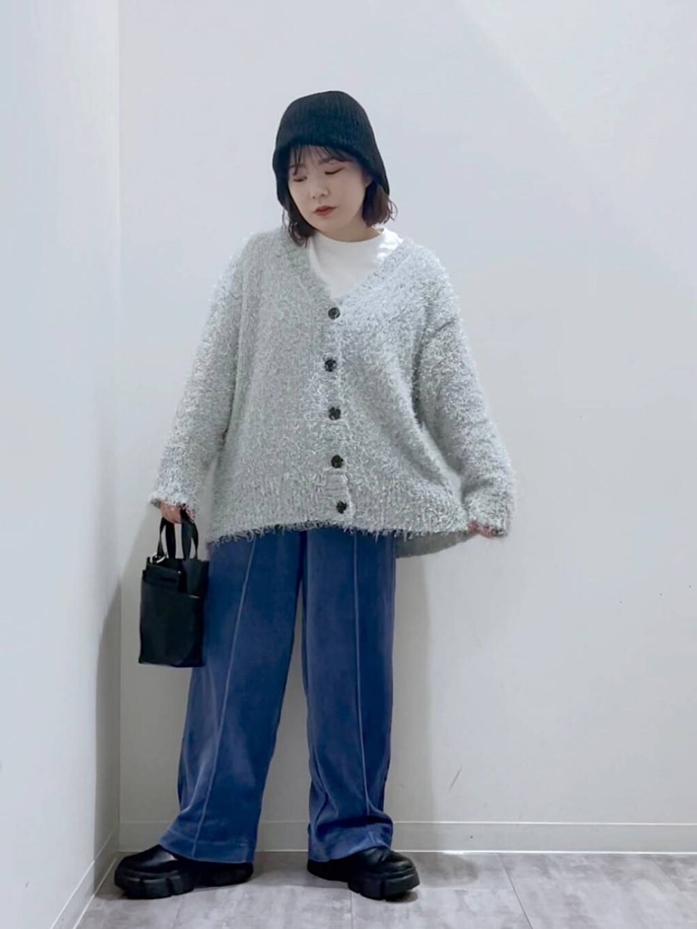 ブラック系のブーツ、ブラック系のショルダーバッグ、グレー系のカーディガン/ボレロを着用したレディースの冬コーディネートの4枚目の写真