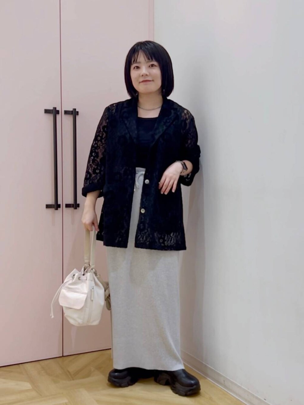 グレー系のスカート、ブラック系のシャツ/ブラウス、ホワイト系のショルダーバッグを着用したレディースの秋コーディネートの2枚目の写真