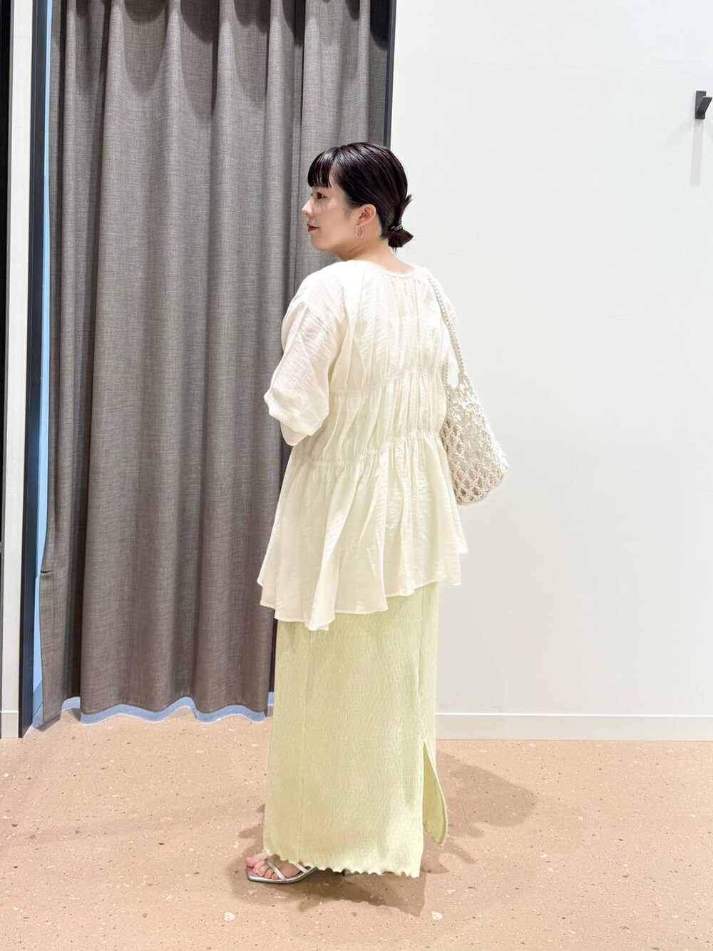 ホワイト系のタンクトップ、ホワイト系のトートバッグ、ホワイト系のシャツ/ブラウスを着用したレディースの春コーディネートの2枚目の写真