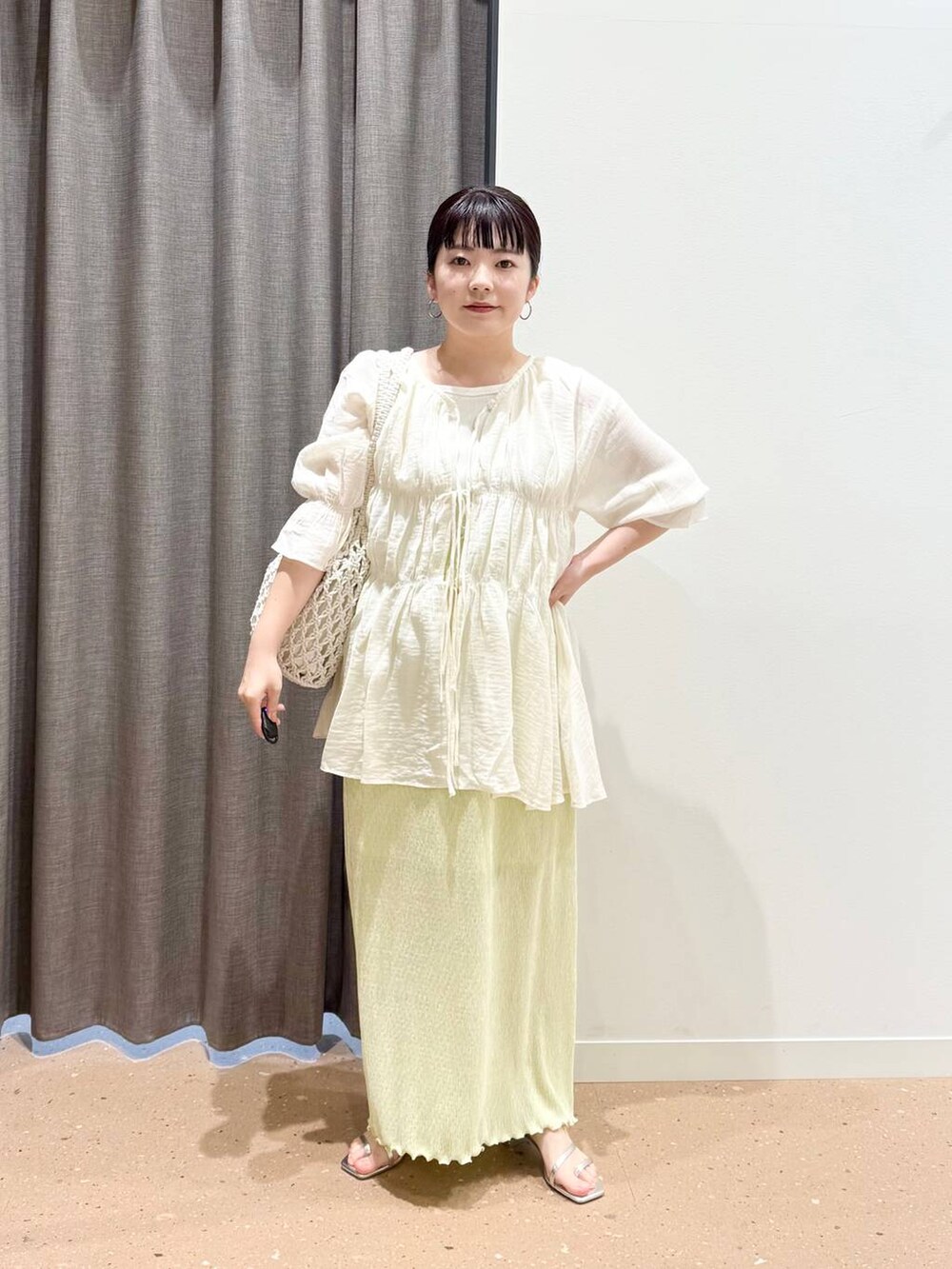 ホワイト系のタンクトップ、ホワイト系のトートバッグ、ホワイト系のシャツ/ブラウスを着用したレディースの春コーディネートの4枚目の写真