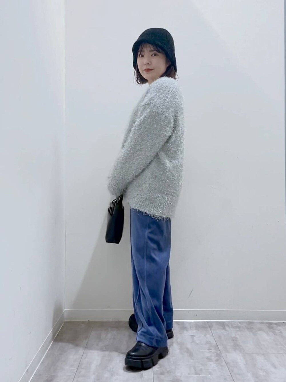 ブラック系のブーツ、ブラック系のショルダーバッグ、グレー系のカーディガン/ボレロを着用したレディースの冬コーディネートの2枚目の写真