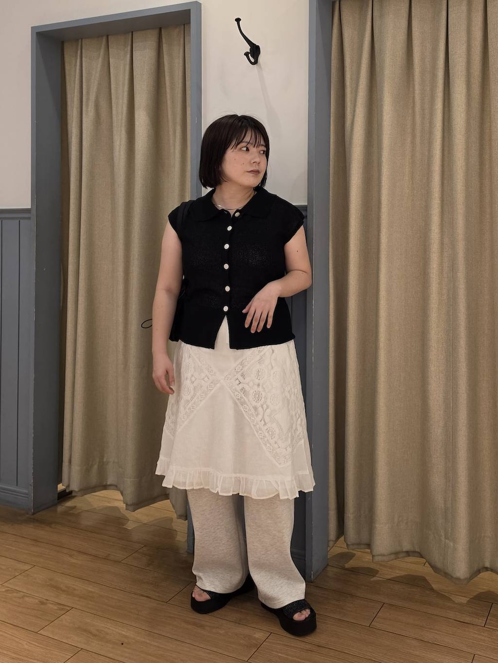 ブラック系のベスト、グレー系のスウェットパンツ、ブラック系のサンダルを着用したレディースの夏コーディネートの2枚目の写真