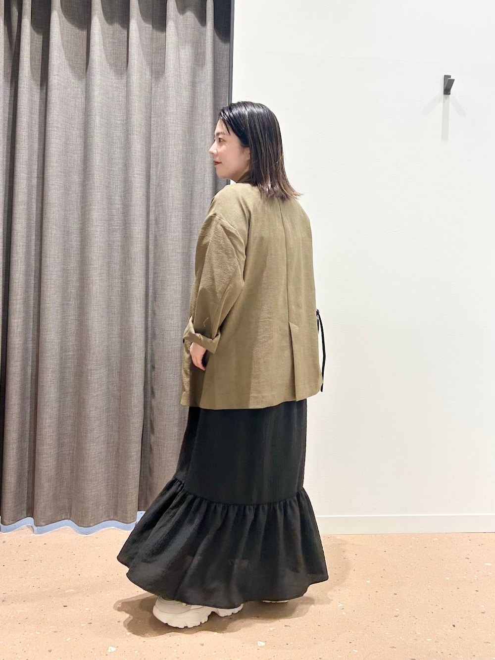 ブラウン系のテーラードジャケット、ブラック系のトートバッグ、ベージュ系のスニーカーを着用したレディースの春コーディネートの2枚目の写真