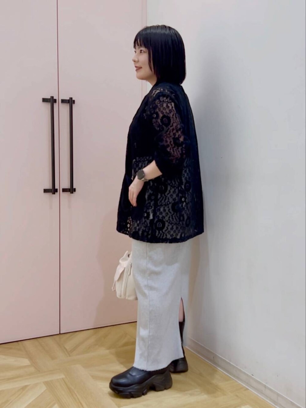 グレー系のスカート、ブラック系のシャツ/ブラウス、ホワイト系のショルダーバッグを着用したレディースの秋コーディネートの3枚目の写真