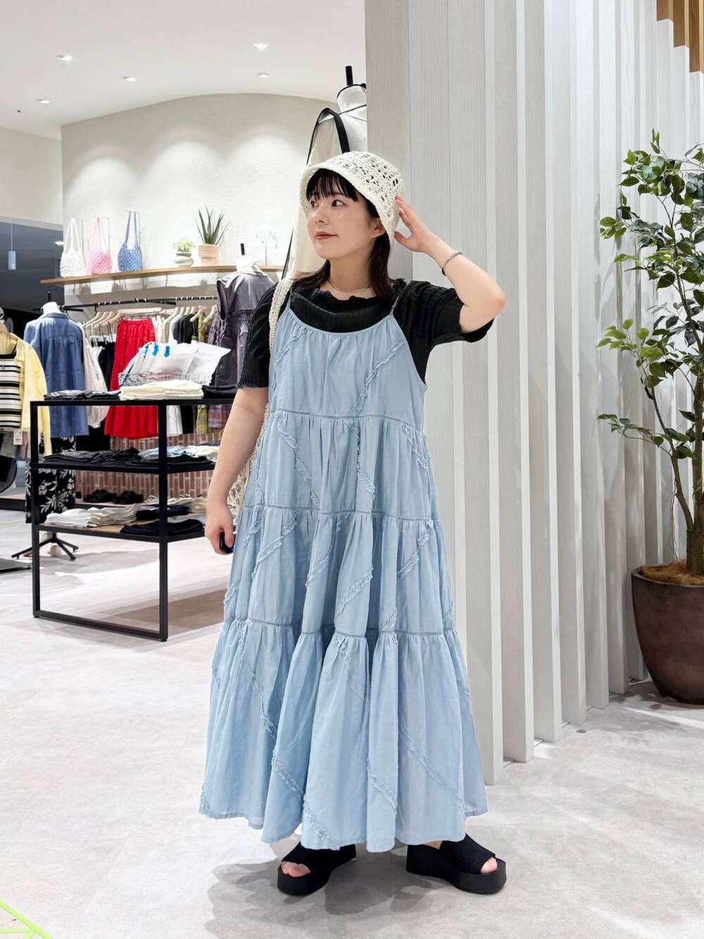 ブラック系のサンダル、ホワイト系のトートバッグ、ブルー系のワンピースを着用したレディースの春コーディネートの4枚目の写真