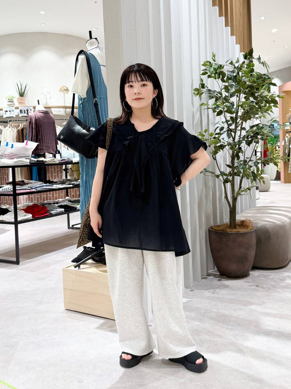 ブラック系のサンダル、その他のトートバッグ、グレー系のデニムパンツを着用したレディースの春コーディネートの2枚目の写真