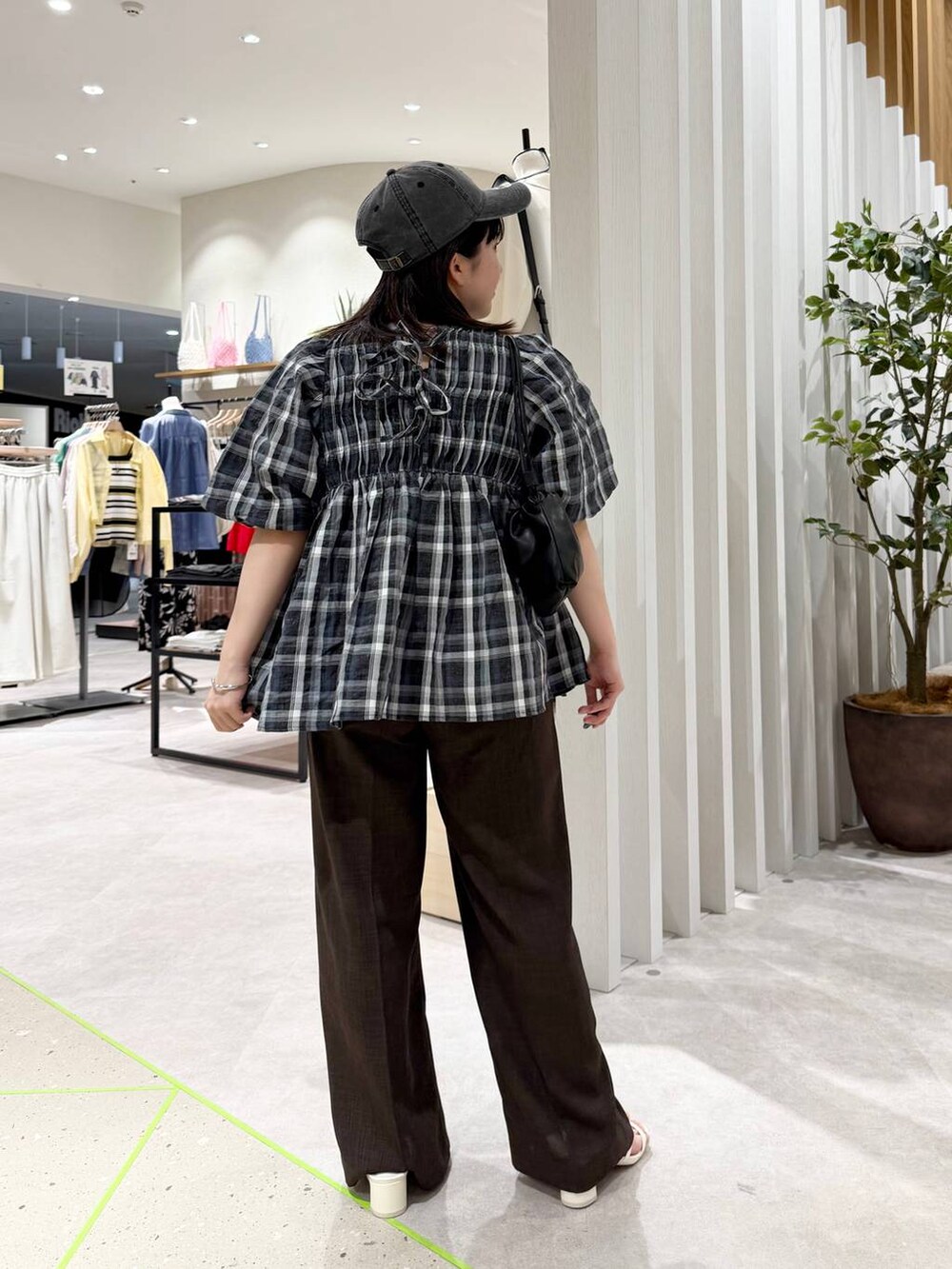 ブラック系のシャツ/ブラウス、ホワイト系のサンダル、ブラック系のショルダーバッグを着用したレディースの春コーディネートの3枚目の写真