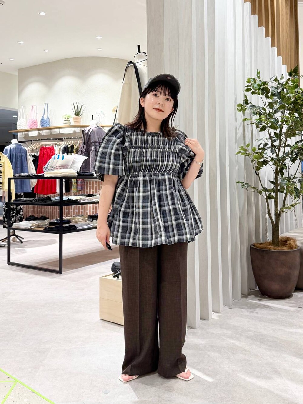 ブラック系のシャツ/ブラウス、ホワイト系のサンダル、ブラック系のショルダーバッグを着用したレディースの春コーディネートの4枚目の写真