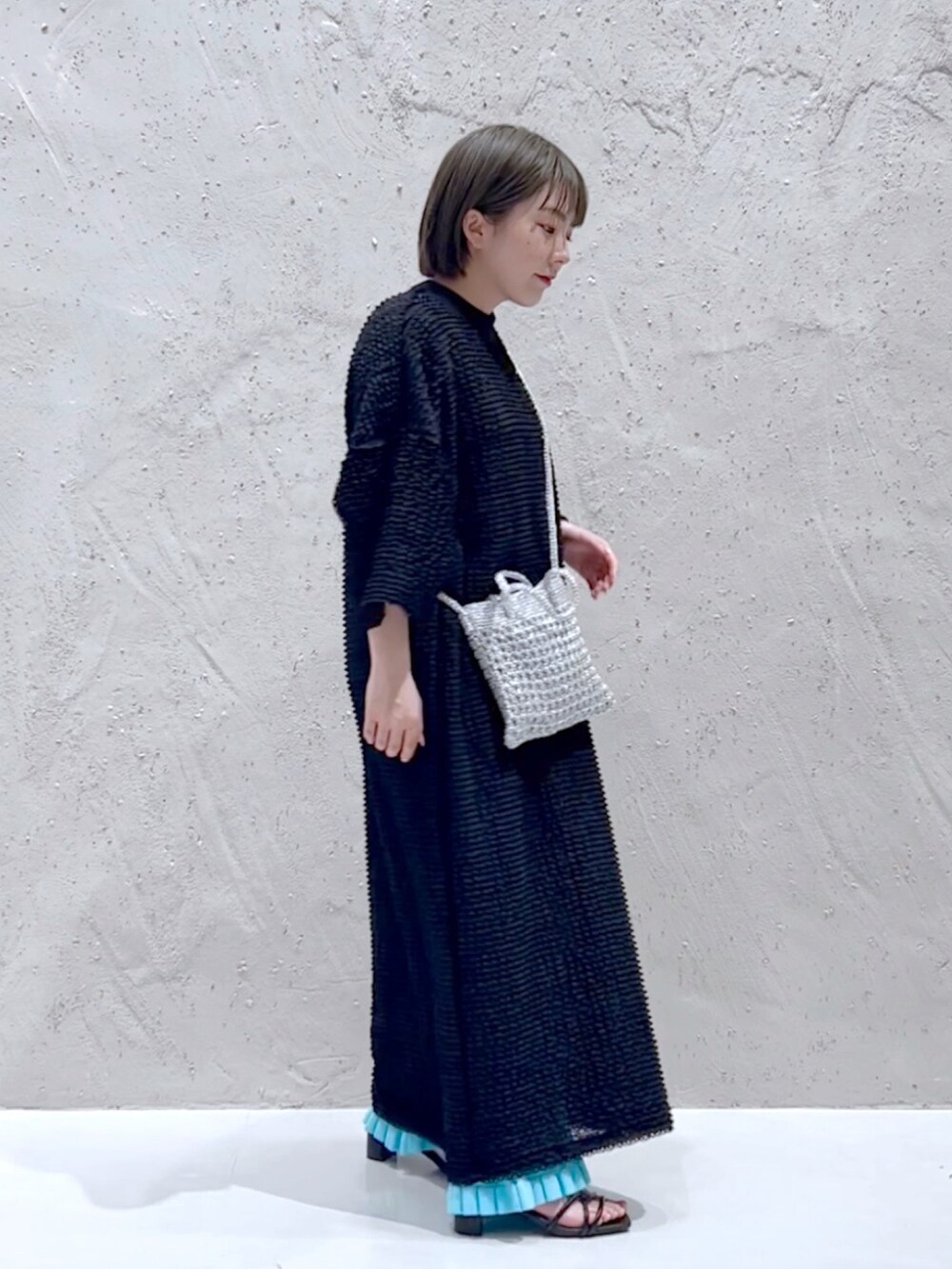 ブラック系のワンピース、ブルー系のその他パンツを着用したレディースの春コーディネートの2枚目の写真