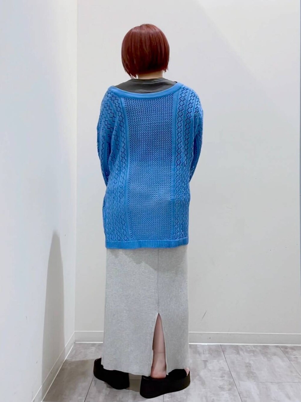 グレー系のスカート、ブルー系のニット/セーター、シルバー系のショルダーバッグを着用したレディースの春コーディネートの3枚目の写真