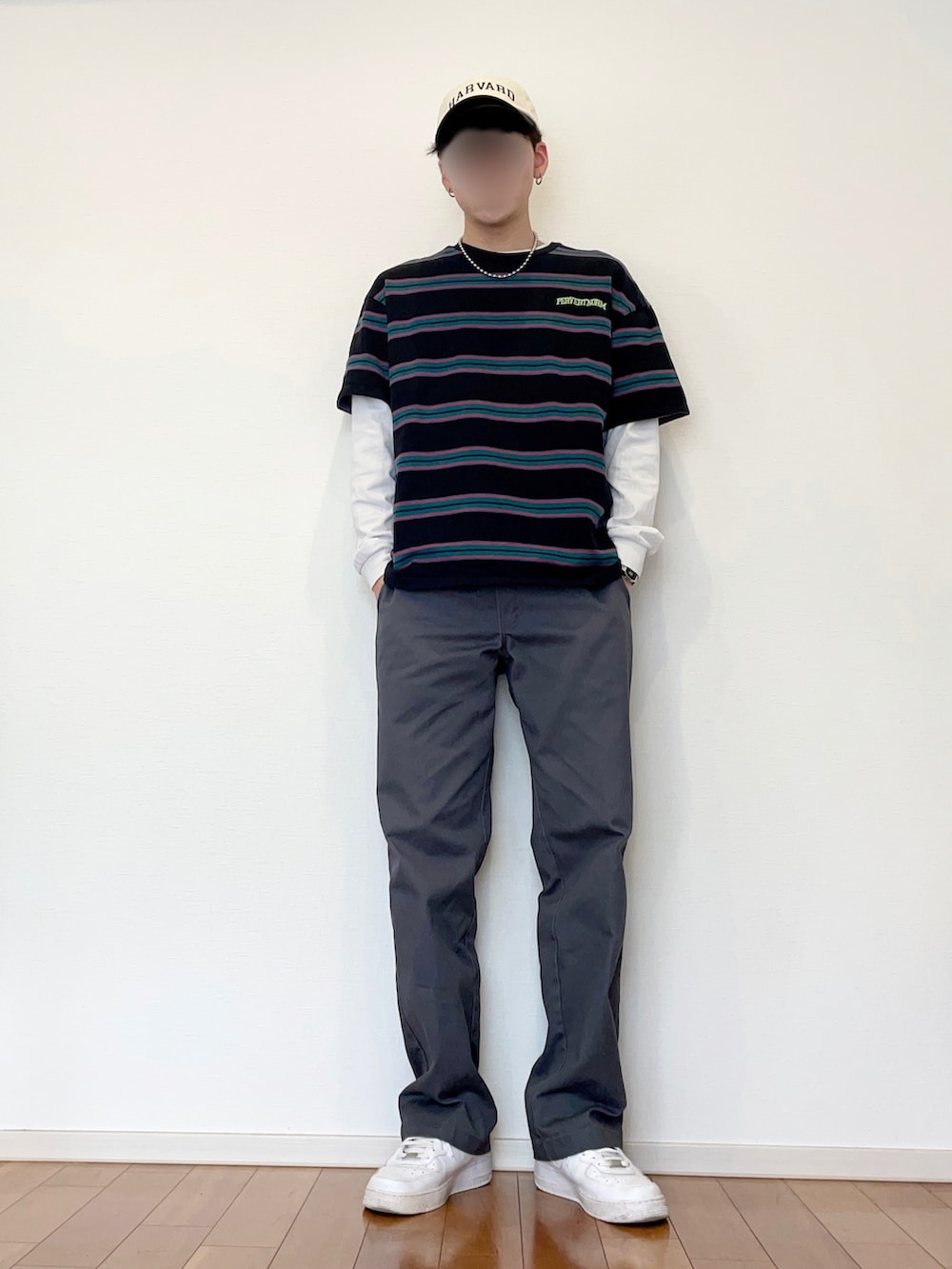 ブラック系のTシャツ/カットソー、グレー系のチノパンツ、ホワイト系のスニーカーを着用したメンズの春コーディネートの2枚目の写真