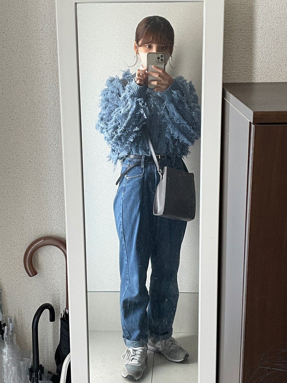 グレー系のスニーカー、ブルー系のデニムパンツ、グレー系のショルダーバッグを着用したレディースの春コーディネートの2枚目の写真