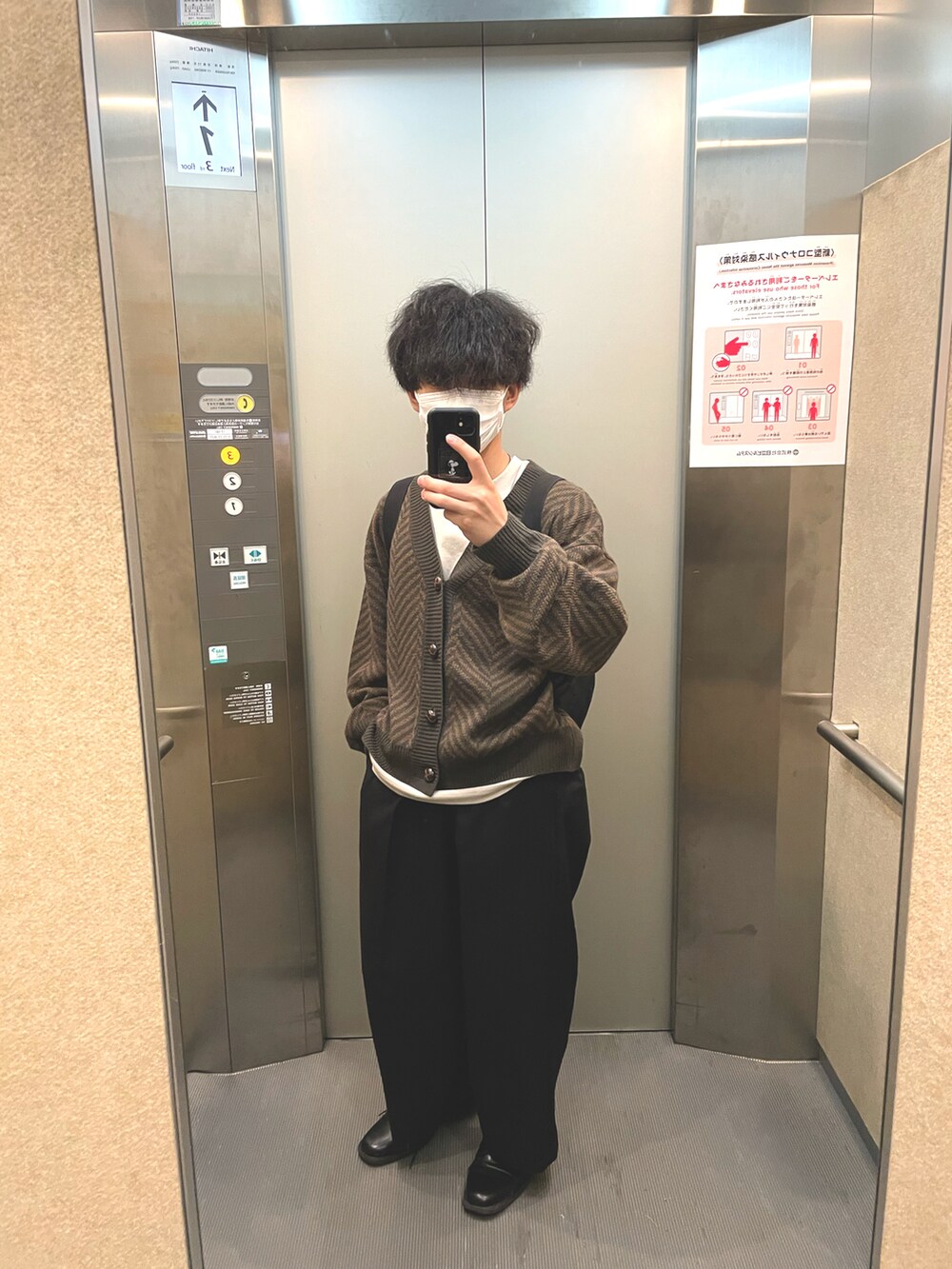 ブラック系のスラックス、ブラック系のスリッポン、ベージュ系のTシャツ/カットソーを着用したメンズの夏コーディネートの2枚目の写真