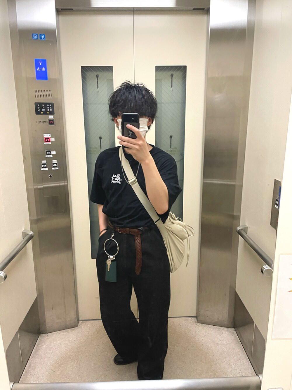 ベージュ系のショルダーバッグ、ブラック系のアンサンブル、ブラック系のデニムパンツを着用したメンズの夏コーディネートの2枚目の写真