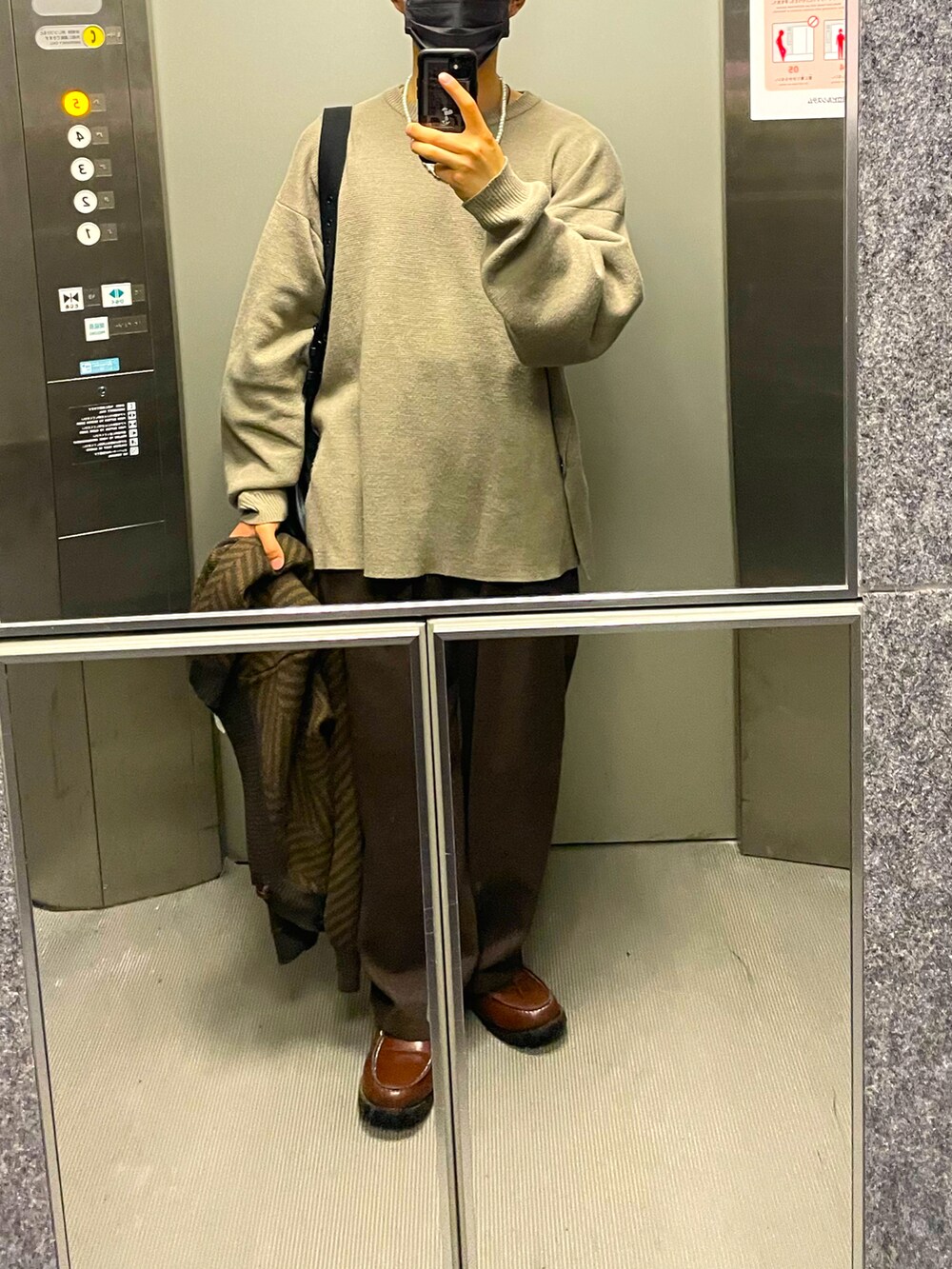 グレー系のニット/セーター、ブラウン系のその他パンツ、ブラウン系のモカシン/デッキシューズを着用したメンズの春コーディネートの2枚目の写真