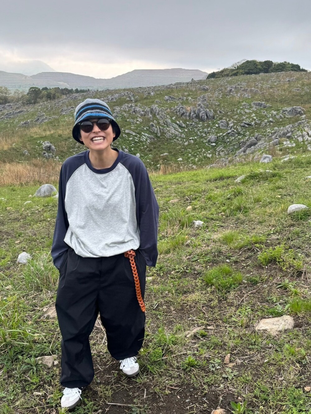 グレー系のTシャツ/カットソー、ブラック系のその他パンツ、ホワイト系のスニーカーを着用したメンズの春コーディネートの2枚目の写真