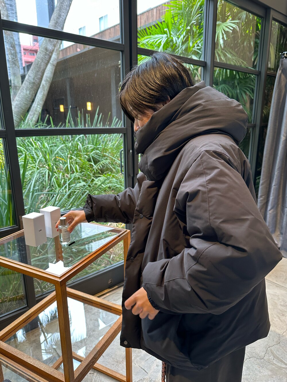 ブラック系のダウンジャケット/コート、グレー系のその他パンツ、ホワイト系のスニーカーを着用したメンズの冬コーディネートの2枚目の写真