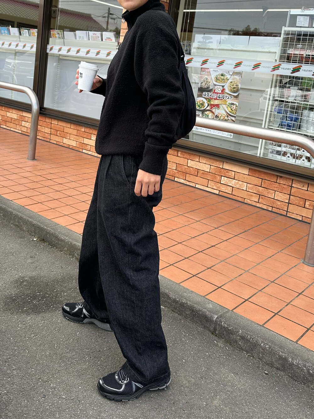 ブラック系のニット/セーター、ブラック系のデニムパンツ、ブラック系のスニーカーを着用したメンズの冬コーディネートの2枚目の写真