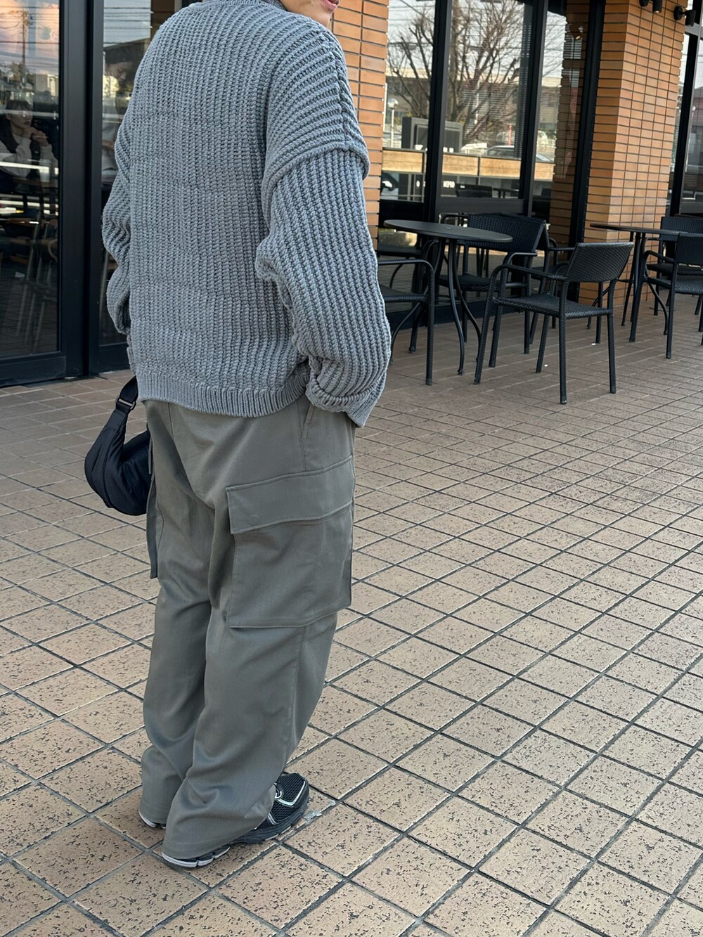 グレー系のブルゾン、グレー系のカーゴパンツ、ブラック系のスニーカーを着用したメンズの冬コーディネートの2枚目の写真