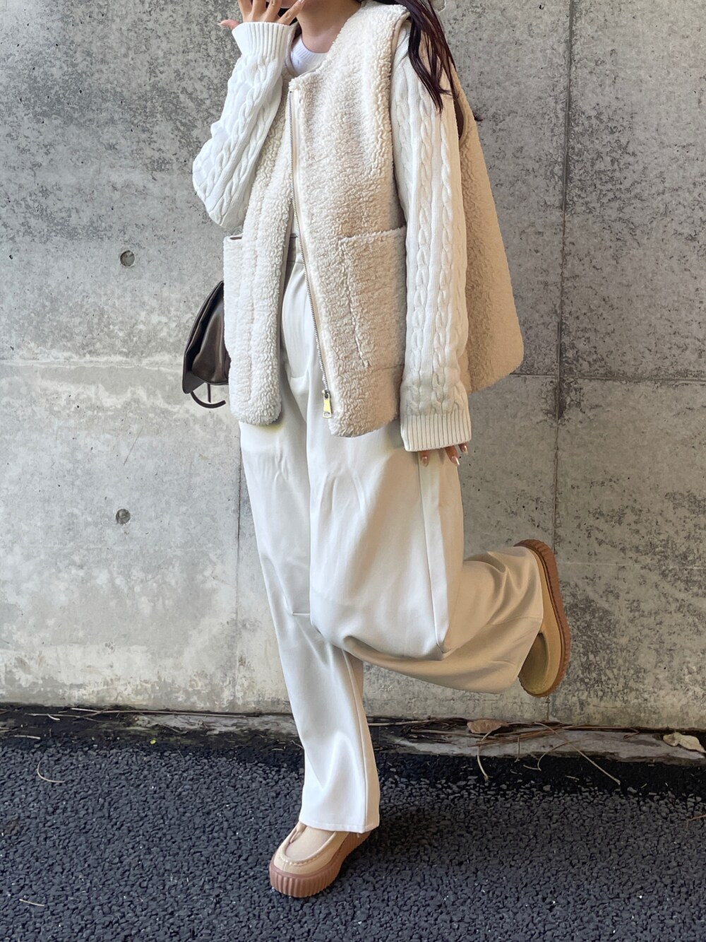 ホワイト系のニット/セーター、ホワイト系のベスト、ホワイト系のスラックスを着用したレディースの秋コーディネートの2枚目の写真