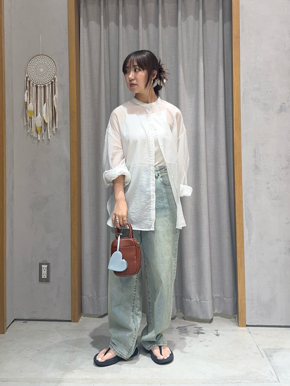 ホワイト系のシャツ/ブラウス、ブルー系のデニムパンツ、ブラウン系のトートバッグを着用したレディースの夏コーディネートの2枚目の写真