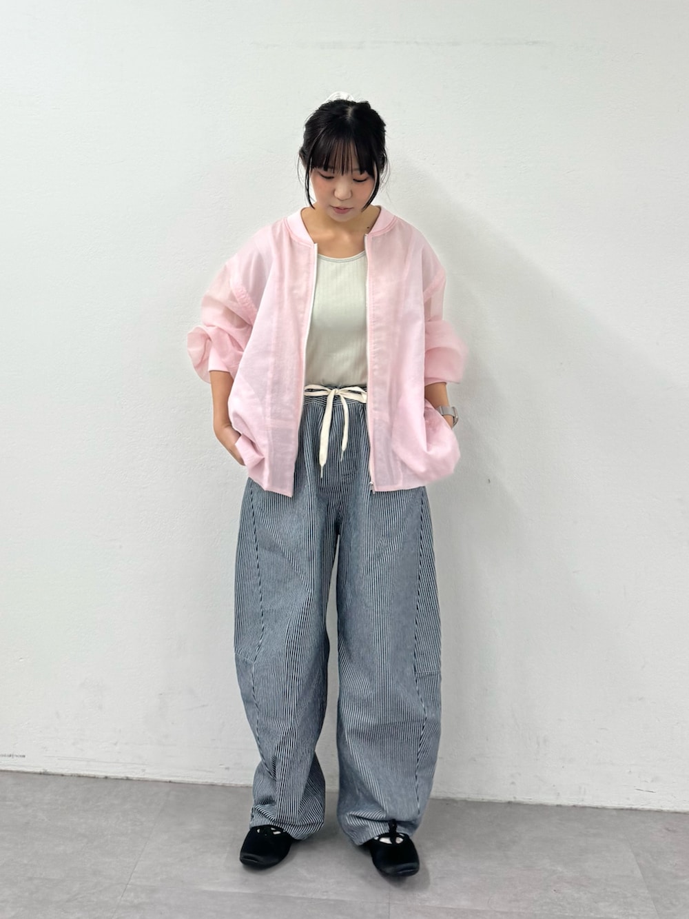 ブルー系のデニムパンツ、ブラック系のパンプス、グレー系のタンクトップを着用したレディースの春コーディネートの2枚目の写真