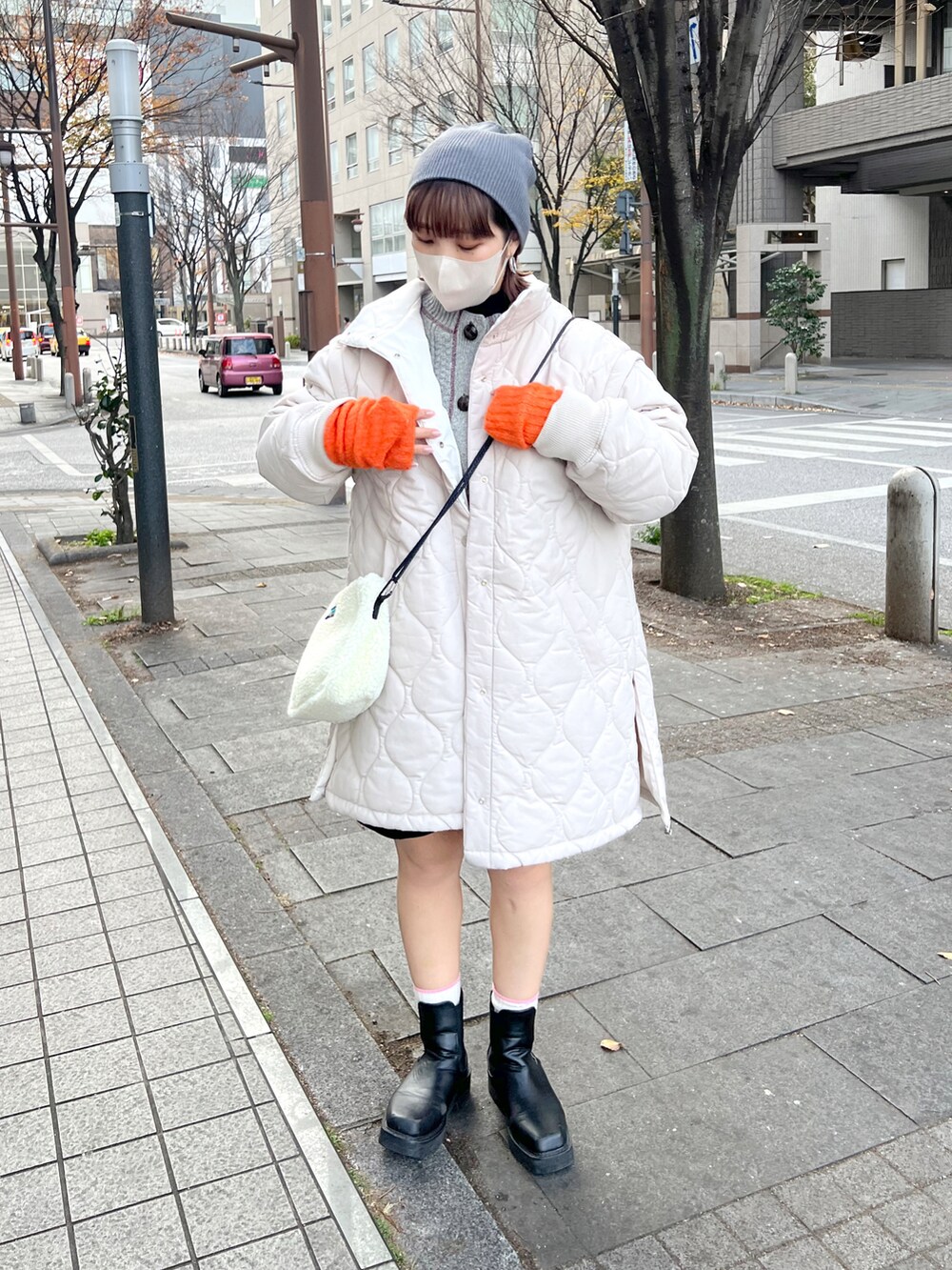 ブラック系のニット/セーター、ホワイト系のその他アウター、ホワイト系のカーディガン/ボレロを着用したレディースの冬コーディネートの3枚目の写真