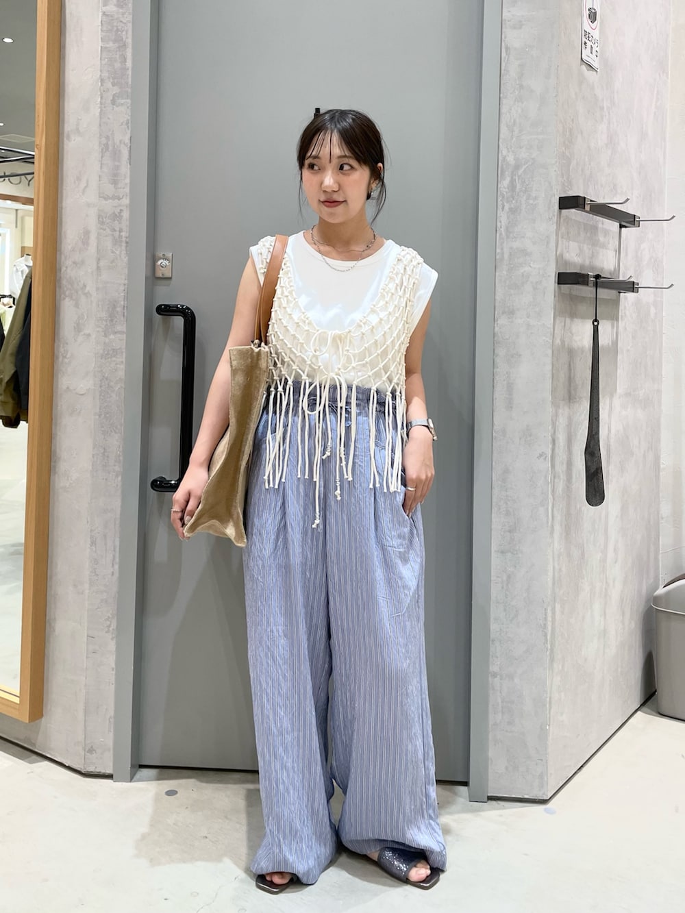 ホワイト系のベスト、ブルー系のその他パンツ、ホワイト系のタンクトップを着用したレディースの春コーディネートの2枚目の写真