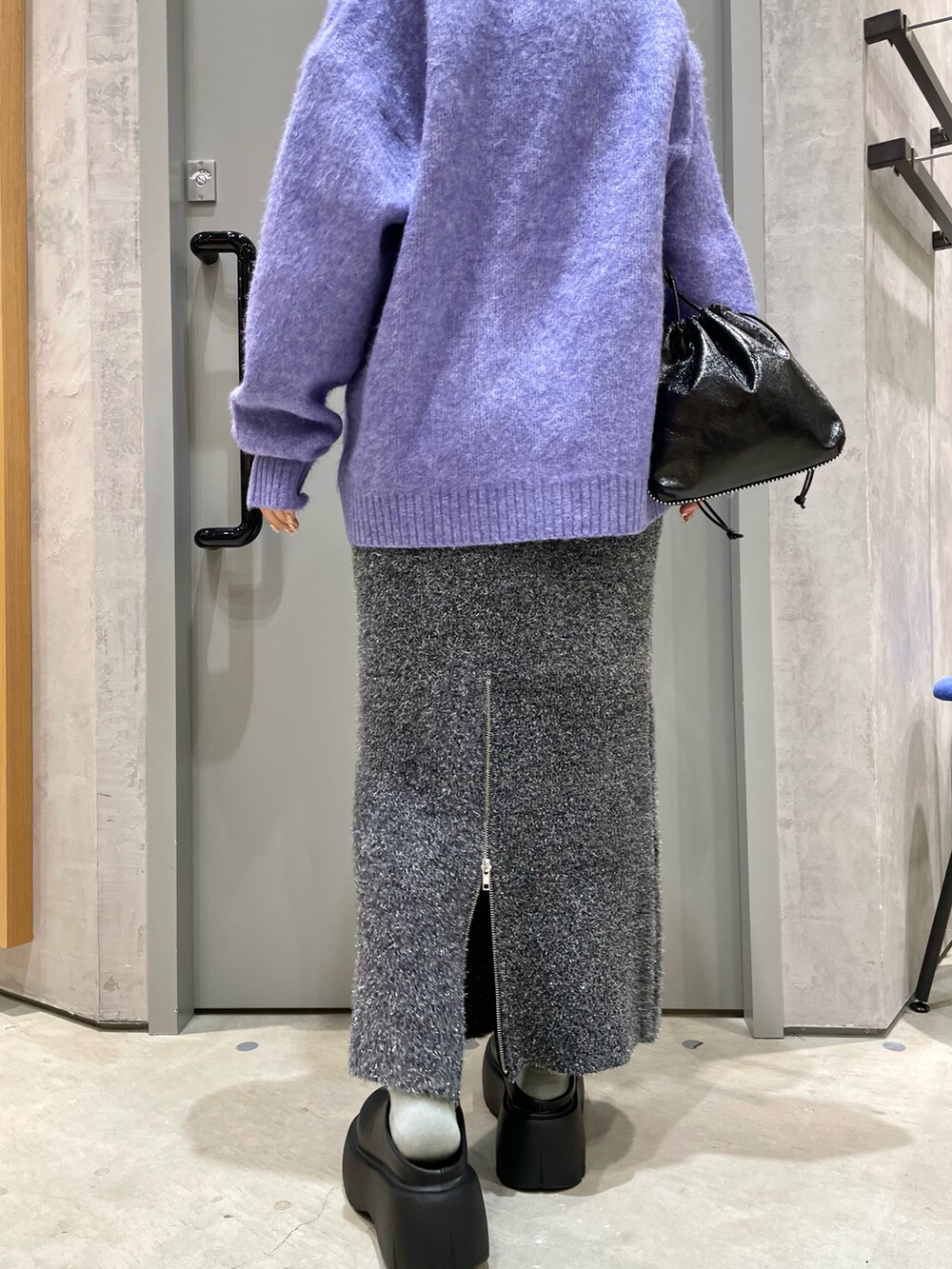 パープル系のカーディガン/ボレロ、ブラック系のバッグ、ブラック系のスカートを着用したレディースの秋コーディネートの4枚目の写真