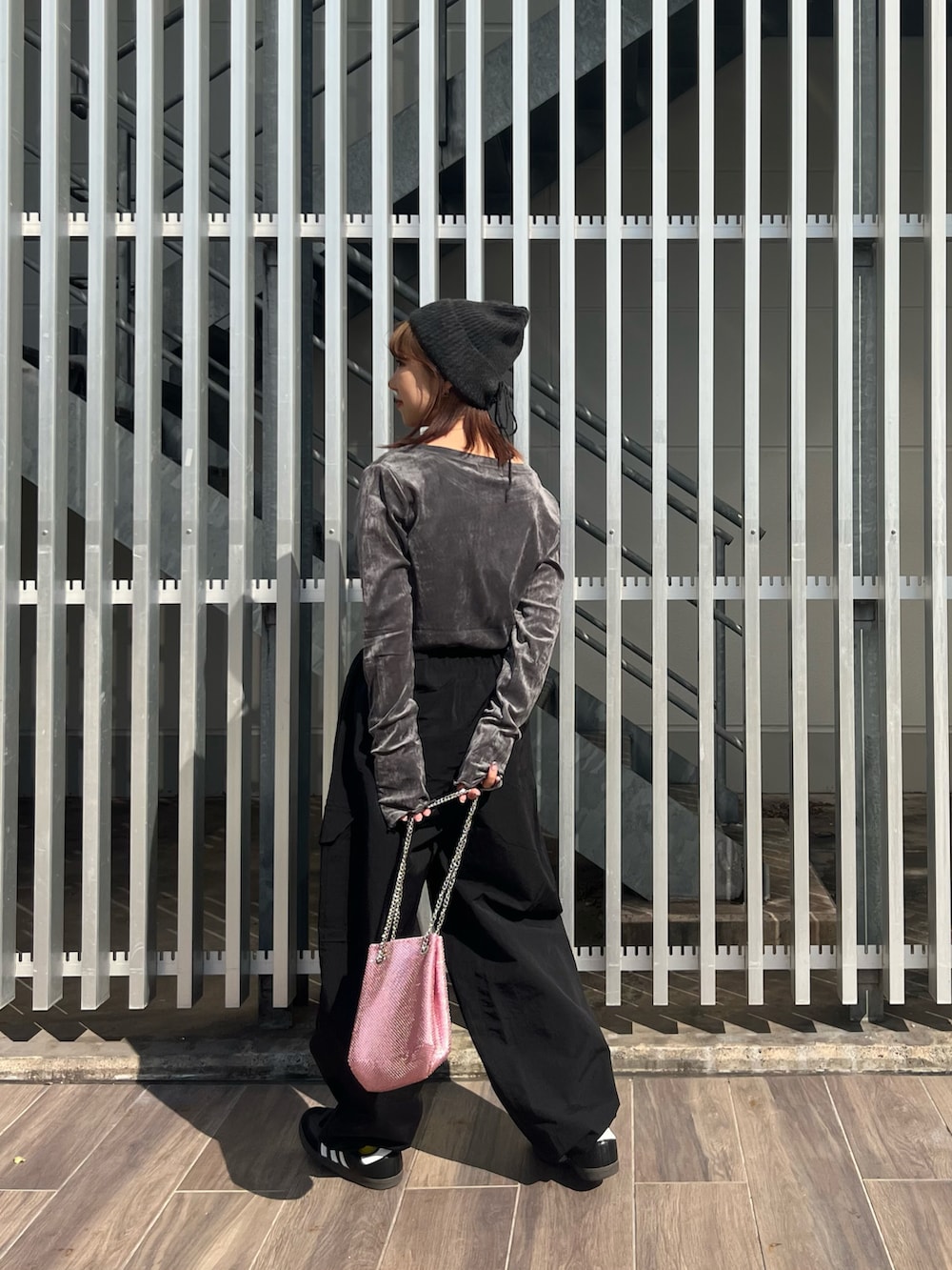 グレー系のTシャツ/カットソー、ブラック系のカーゴパンツ、ピンク系のショルダーバッグを着用したレディースの秋コーディネートの3枚目の写真