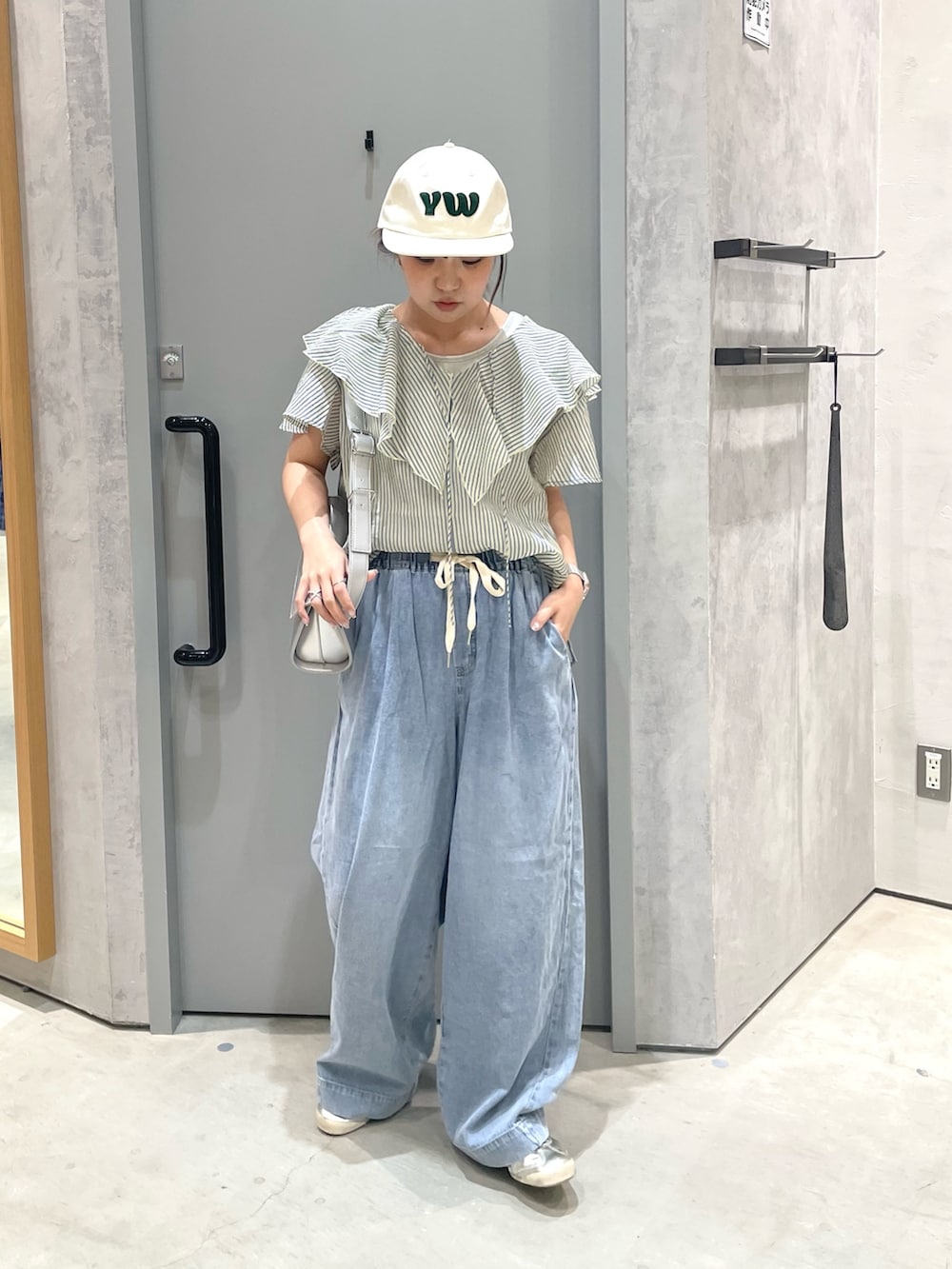 ブルー系のデニムパンツ、グレー系のタンクトップ、イエロー系のシャツ/ブラウスを着用したレディースの夏コーディネートの2枚目の写真