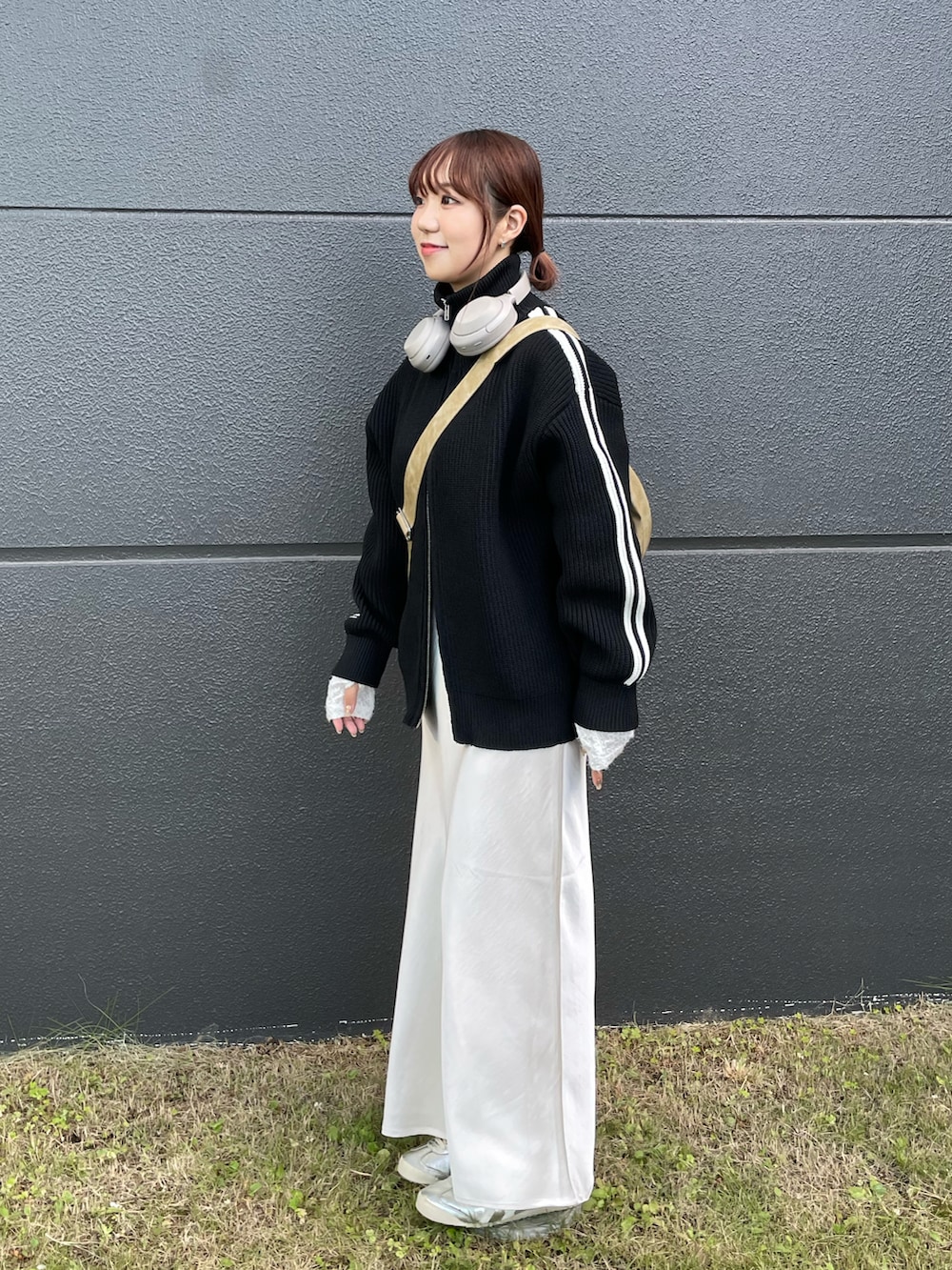 ベージュ系のショルダーバッグ、ホワイト系のスカート、ブラック系のニット/セーターを着用したレディースの秋コーディネートの2枚目の写真