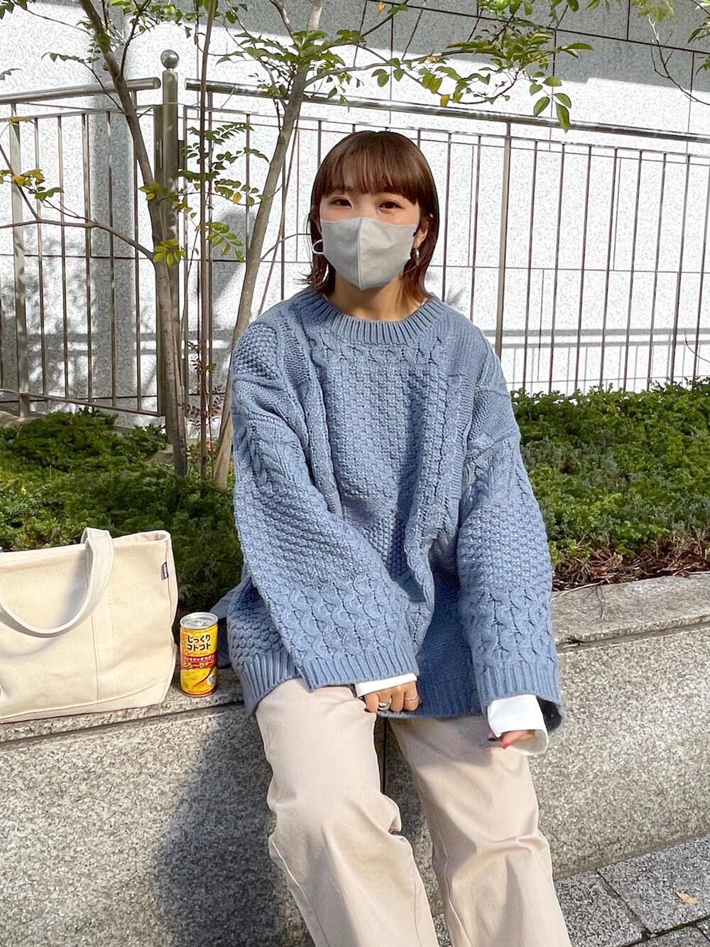 ブルー系のニット/セーター、ホワイト系のチノパンツ、ホワイト系のトートバッグを着用したレディースの秋コーディネートの4枚目の写真