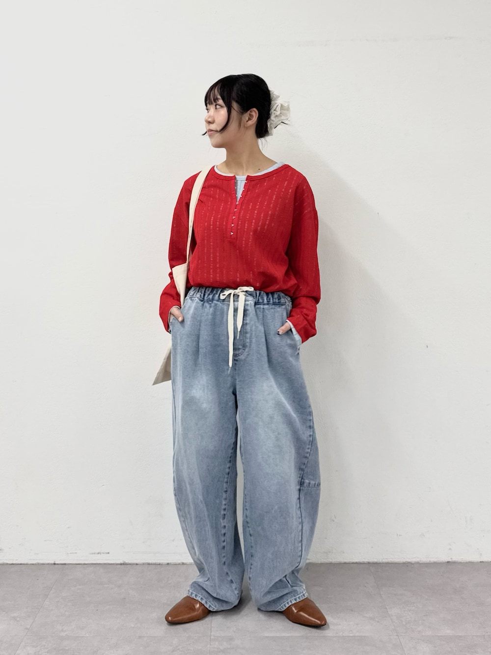 ブルー系のデニムパンツ、ブルー系のTシャツ/カットソー、レッド系のTシャツ/カットソーを着用したレディースの春コーディネートの3枚目の写真