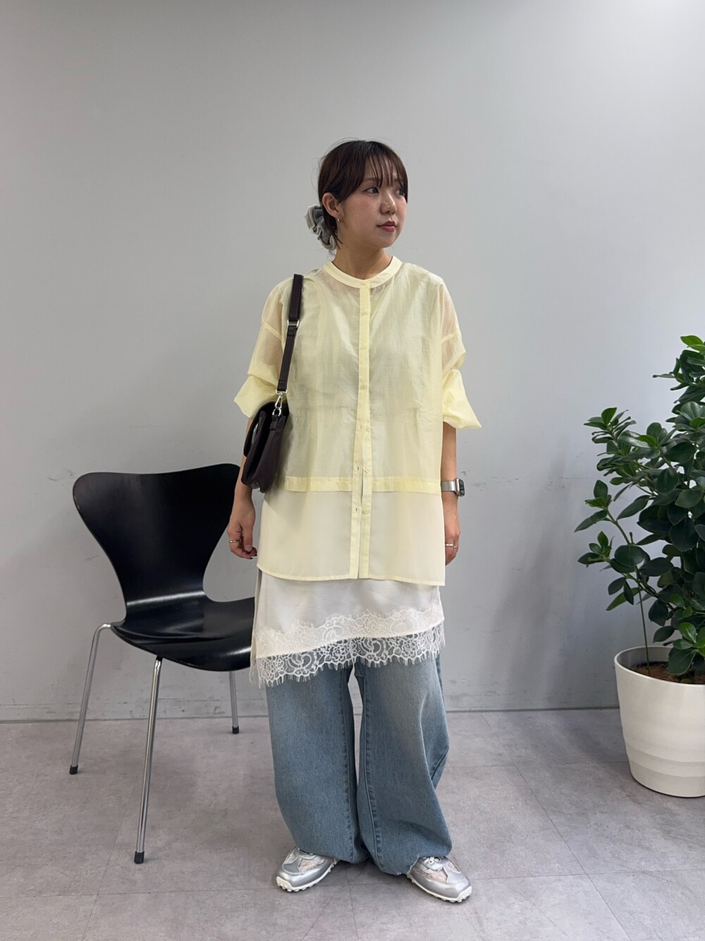 イエロー系のシャツ/ブラウス、ホワイト系のスカート、ブラウン系のショルダーバッグを着用したレディースの春コーディネートの2枚目の写真