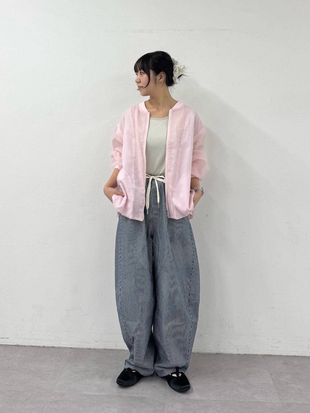 ブルー系のデニムパンツ、ブラック系のパンプス、グレー系のタンクトップを着用したレディースの春コーディネートの3枚目の写真