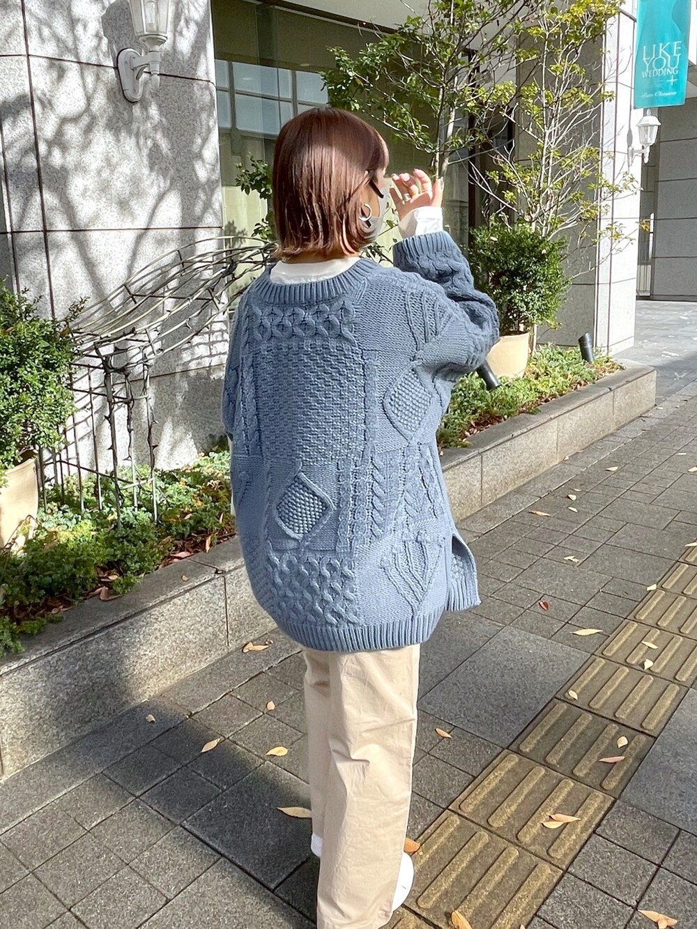 ブルー系のニット/セーター、ホワイト系のチノパンツ、ホワイト系のトートバッグを着用したレディースの秋コーディネートの2枚目の写真
