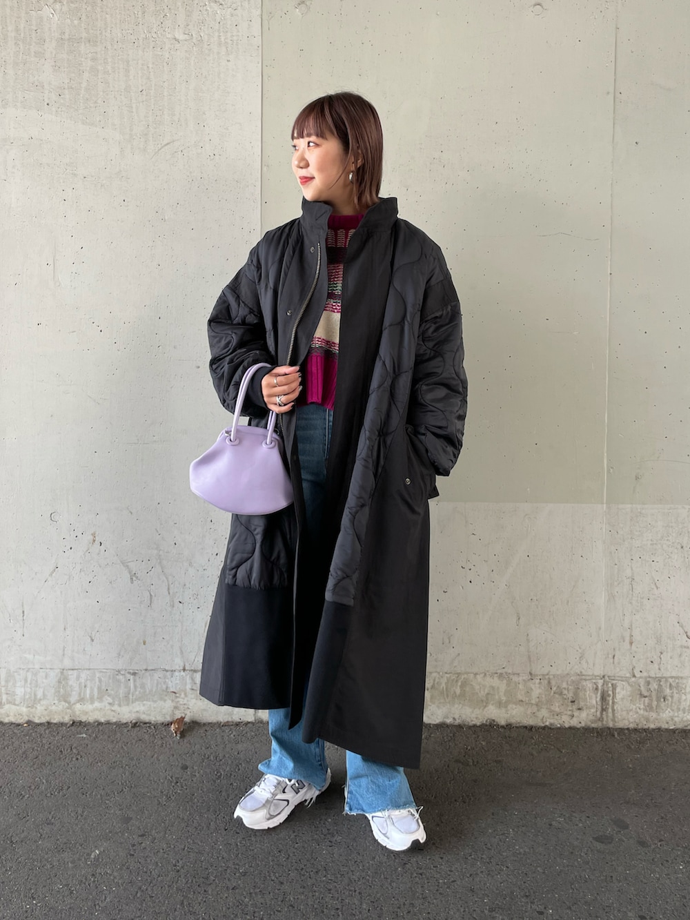 ピンク系のニット/セーター、ブラック系のその他アウター、ブルー系のデニムパンツを着用したレディースの秋コーディネートの2枚目の写真