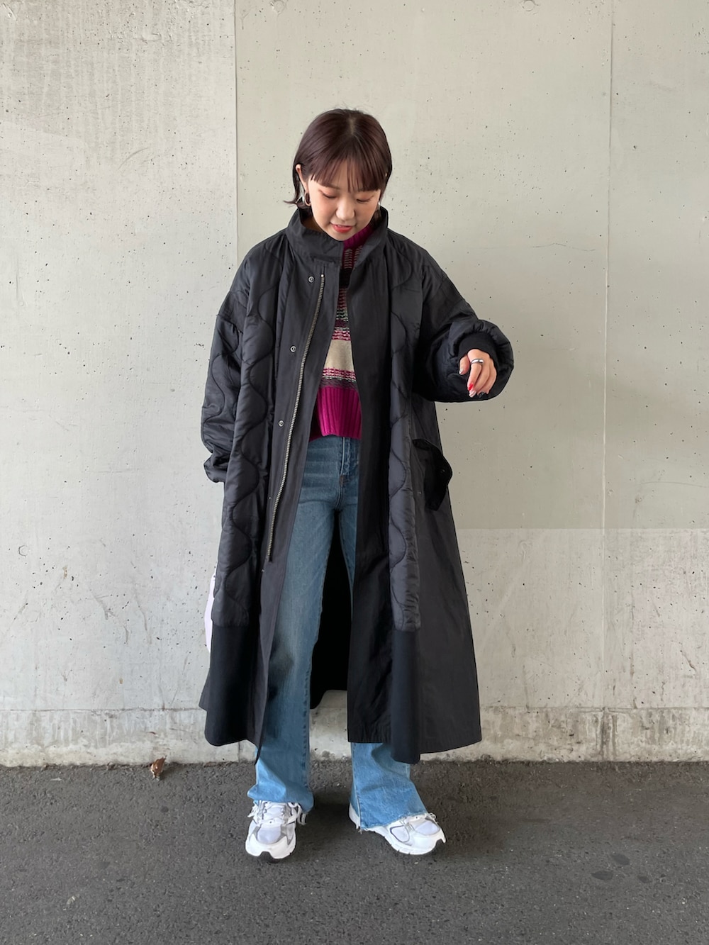 ピンク系のニット/セーター、ブラック系のその他アウター、ブルー系のデニムパンツを着用したレディースの秋コーディネートの3枚目の写真