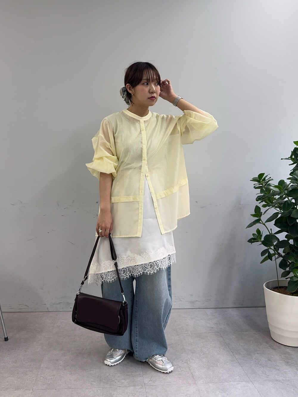 イエロー系のシャツ/ブラウス、ホワイト系のスカート、ブラウン系のショルダーバッグを着用したレディースの春コーディネートの3枚目の写真
