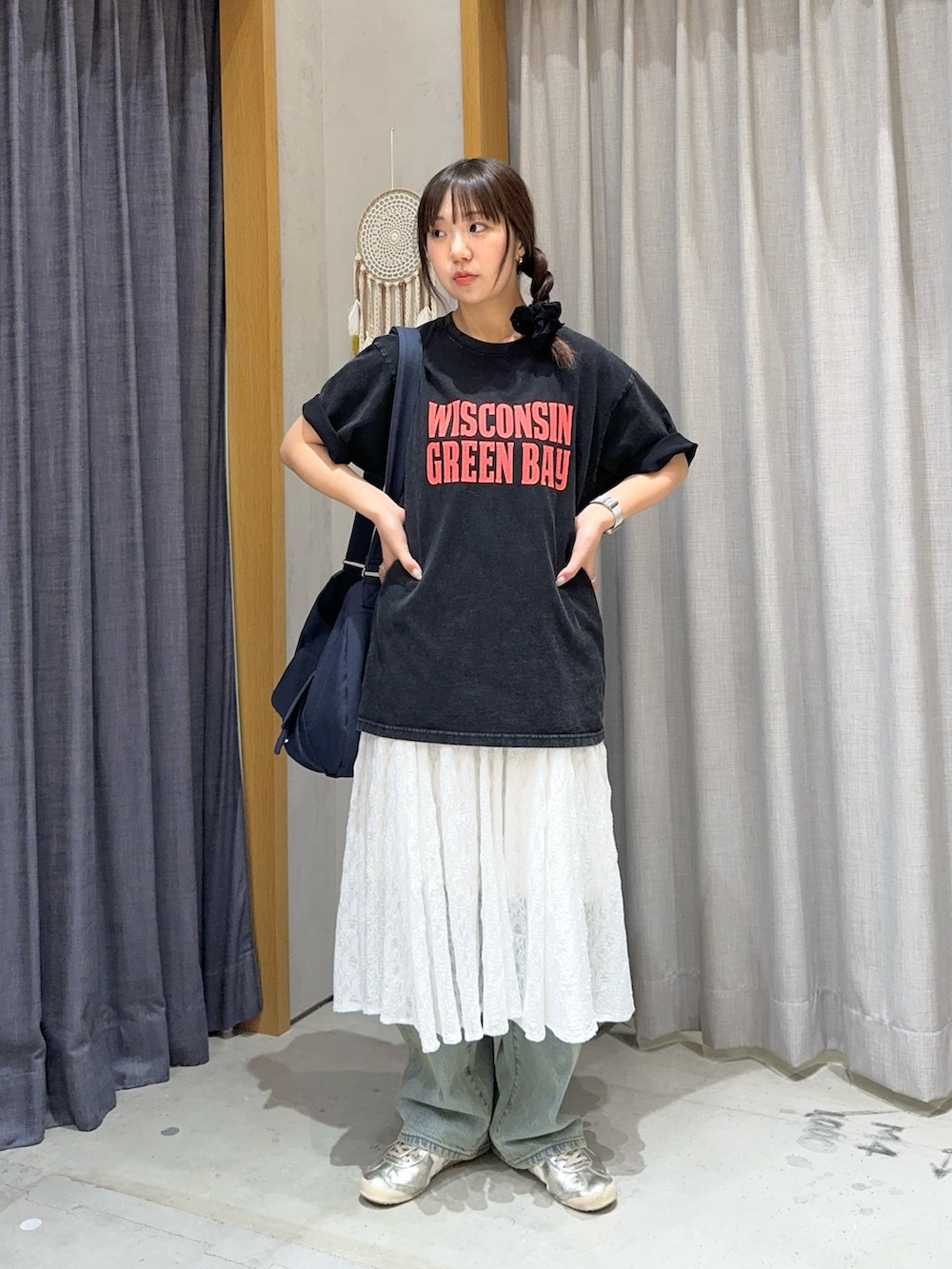 ブルー系のショルダーバッグ、ホワイト系のスカート、ブルー系のデニムパンツを着用したレディースの春コーディネートの2枚目の写真