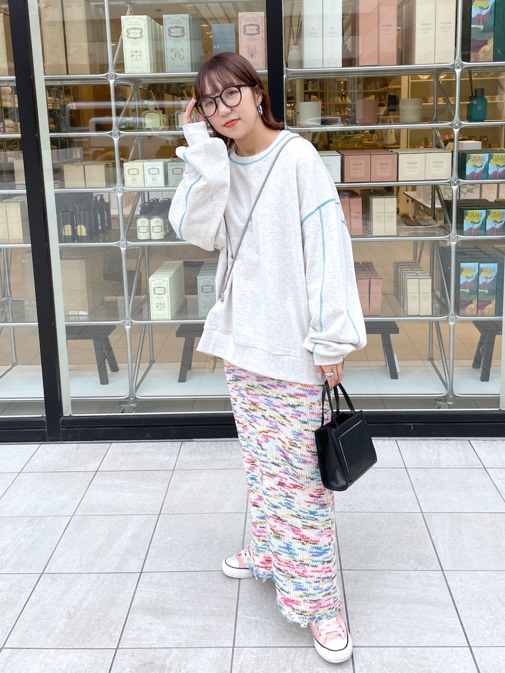 グレー系のスウェット、ピンク系のスカート、ピンク系のスニーカーを着用したレディースの秋コーディネートの2枚目の写真